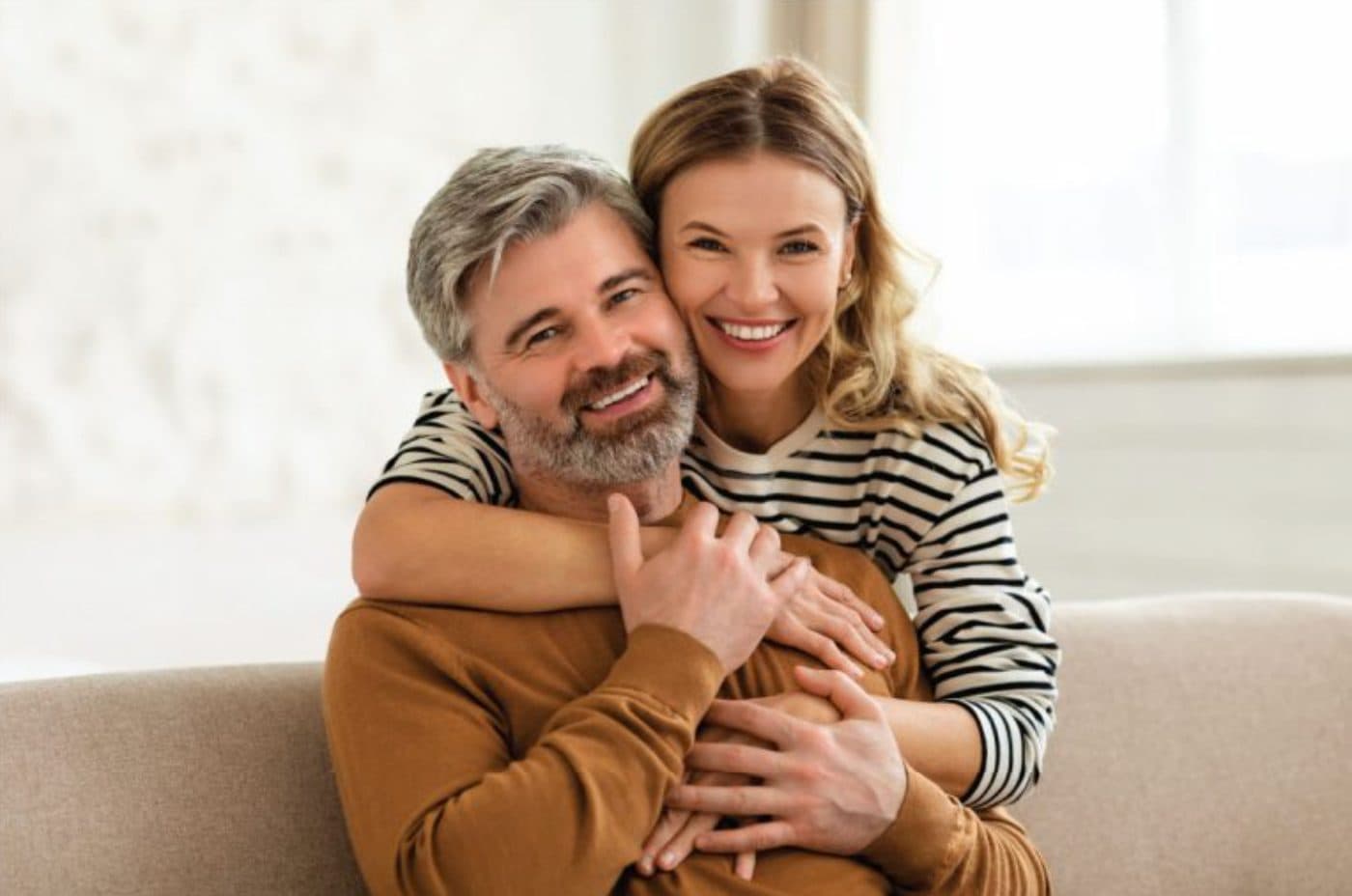 Happy couple hugging on the couch