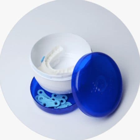 Custom-fitted oral sleep device in its blue storage case
